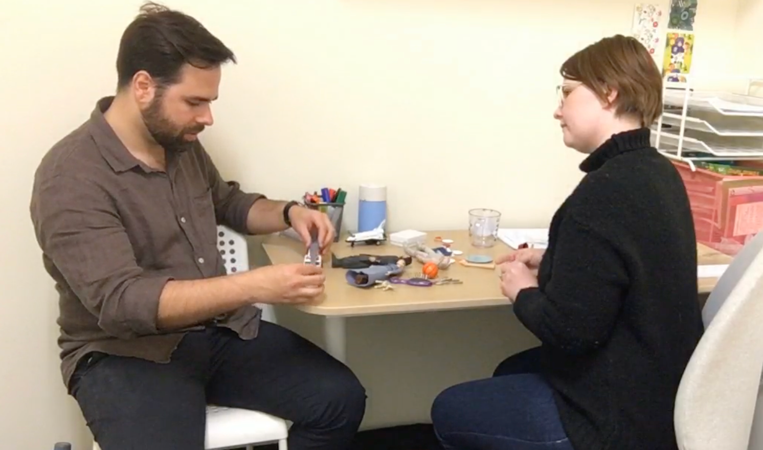 Psychologist conducting a play-based assessment with figurines